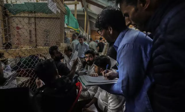 Political party representatives watch as polling officials count the votes in the recent election for a local government in Indian-controlled Kashmir on the outskirts of Srinagar, Tuesday, Oct. 8, 2024. (AP Photo/Mukhtar Khan)