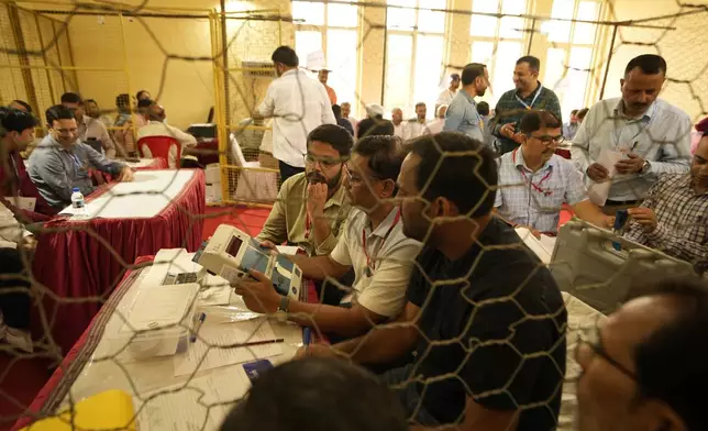 Election officers count votes for the recent election at a counting center in Jammu, India, Tuesday, Oct. 8, 2024. (AP Photo/Channi Anand)