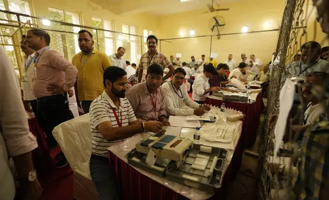 Election officers count votes for the recent election at a counting center in Jammu, India, Tuesday, Oct. 8, 2024. (AP Photo/Channi Anand)