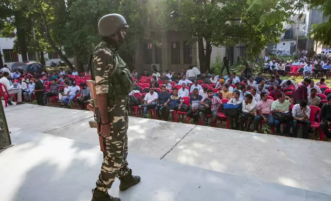 A security person guards as polling officials wait to collect electronic voting machines and other polling material on the eve of the third phase of the Jammu and Kashmir Assembly election, in Jammu, India, Monday, Sept.30, 2024.(AP Photo/Channi Anand)