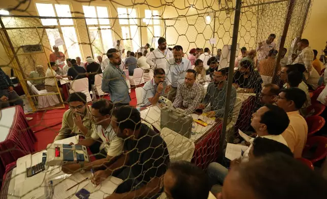 Election officers count votes for the recent election at a counting center in Jammu, India, Tuesday, Oct. 8, 2024. (AP Photo/Channi Anand)