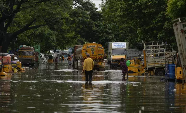 People wade through flooded street after heavy rains in Chennai, India, Wednesday, Oct.16, 2024. (AP Photo/Mahesh Kumar A.)