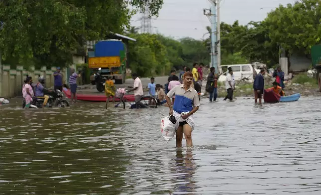 A man wades through a flooded street after heavy rains in Chennai, India, Wednesday, Oct. 16, 2024. (AP Photo/Mahesh Kumar A.)