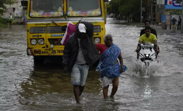 People wade through a flooded street after heavy rains in Chennai, India, Wednesday, Oct. 16, 2024. (AP Photo/Mahesh Kumar A.)