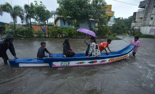 People use a boat on a flooded street to reach safer place during heavy rains in Chennai, India, Wednesday, Oct.16, 2024. (AP Photo/Mahesh Kumar A.)