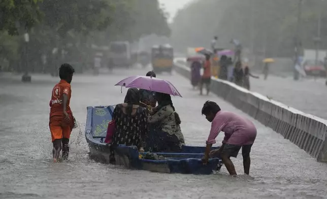 People use a boat on a flooded street to reach safer place during heavy rains in Chennai, India, Wednesday, Oct. 16, 2024. (AP Photo/Mahesh Kumar A.)