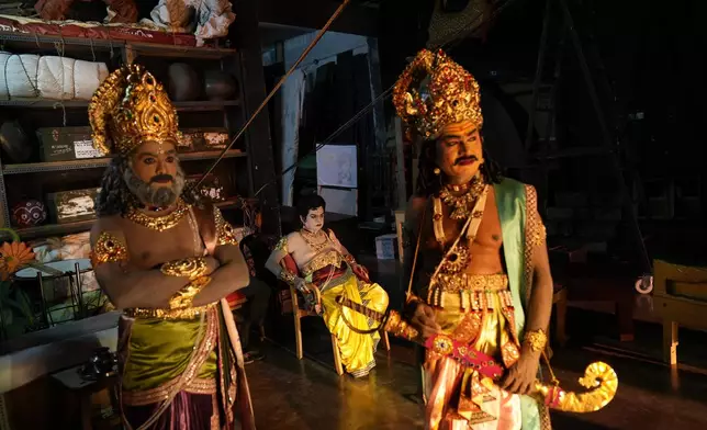 Lakshmana Dassaru, center, dressed in the character of Hindu god Rama, waits backstage with his fellow artists before their performance at a theater during Dussehra festivities, in Mysuru, India, Thursday, Oct. 10, 2024. (AP Photo/Aijaz Rahi)