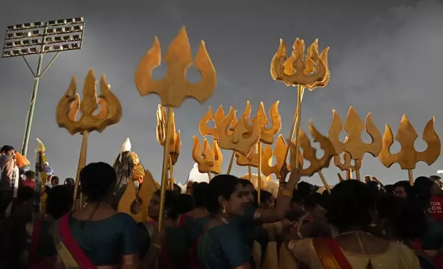 Artists hold Trishuls or tridents as they wait to perform during Dussehra festivities, in Mysuru, India, Friday, Oct. 11, 2024. (AP Photo/Aijaz Rahi)