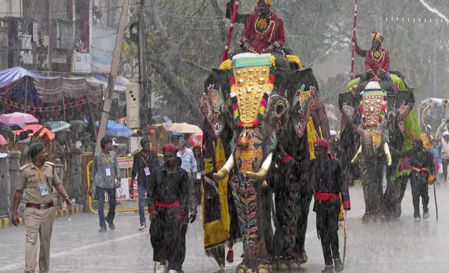 Mahouts ride decorated elephants as it rains during a procession on the last day of the Dussehra festivities, in Mysuru, India, Saturday, Oct. 12, 2024. (AP Photo/Aijaz Rahi)