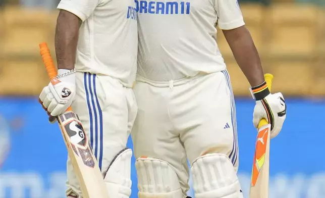 India's Rishabh Pant, left, celebrates with batting partner Sarfaraz Khan after scoring fifty runs during the day four of the first cricket test match between India and New Zealand at the M.Chinnaswamy Stadium, in Bengaluru, India, Saturday, Oct. 19, 2024. (AP Photo/Aijaz Rahi)