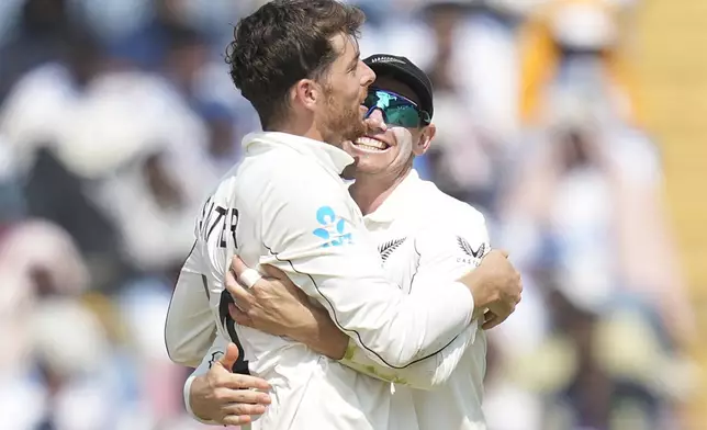 New Zealand's Mitchell Santner, left, and New Zealand's captain Tom Latham celebrates the dismissal of India's Sarfaraz Khan during the day three of the second cricket test match between India and New Zealand at the Maharashtra Cricket Association Stadium , in Pune, India, Saturday, Oct. 26, 2024. (AP Photo/Rafiq Maqbool)