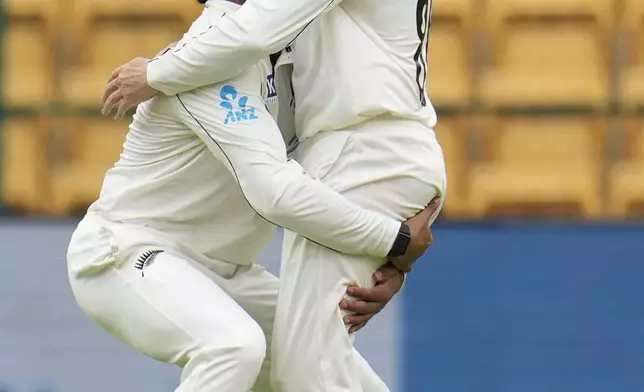 New Zealand's Devon Conway, right, celebrates with teammate Rachin Ravindra after taking the catch to dismiss India's Sarfaraz Khan during the day two of the first cricket test match between India and New Zealand at the M.Chinnaswamy Stadium, in Bengaluru, India, Thursday, Oct. 17, 2024. (AP Photo/Aijaz Rahi)