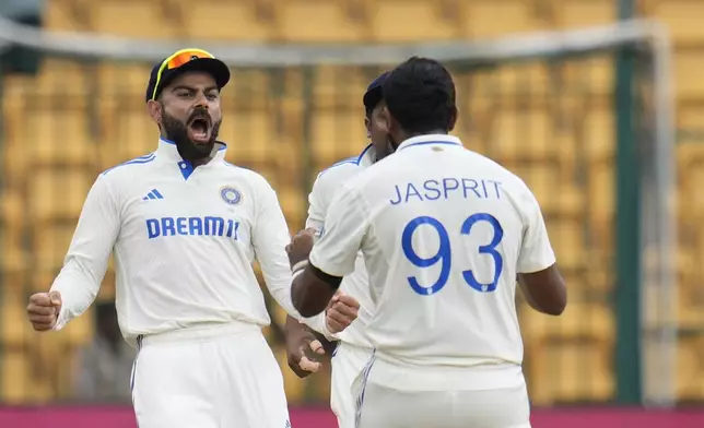 India's Jasprit Bumrah, right, celebrates with teammate Virat Kohli after the dismissal of New Zealand's captain Tom Latham during the day five of the first cricket test match between India and New Zealand at the M.Chinnaswamy Stadium, in Bengaluru, India, Sunday, Oct. 20, 2024. (AP Photo/Aijaz Rahi)