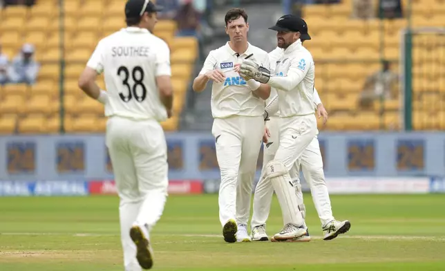 New Zealand's Matt Henry, center, celebrates with teammates after the dismissal of India's Ravindra Jadeja during the day two of the first cricket test match between India and New Zealand at the M.Chinnaswamy Stadium, in Bengaluru, India, Thursday, Oct. 17, 2024. (AP Photo/Aijaz Rahi)