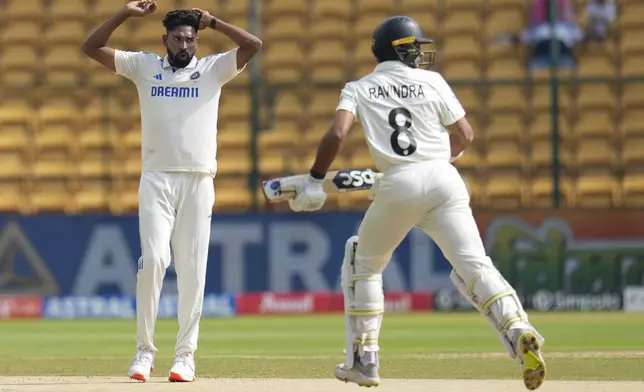 India's Mohammad Siraj, left, reacts after bowling a delivery to New Zealand's Rachin Ravindra, right, during the day three of the first cricket test match between India and New Zealand at the M.Chinnaswamy Stadium, in Bengaluru, India, Friday, Oct. 18, 2024. (AP Photo/Aijaz Rahi)