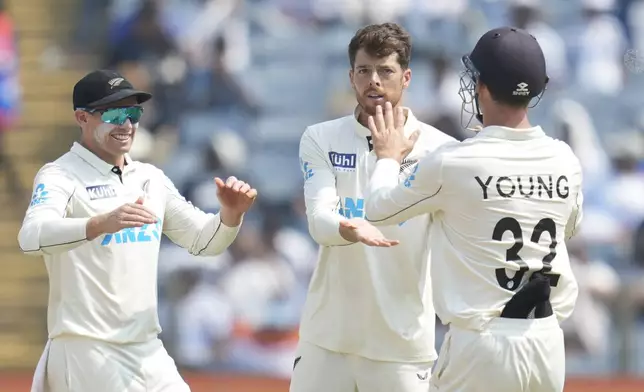 New Zealand's Mitchell Santner, second from right, celebrates the dismissal of India's Ravichandran Ashwin with his team mates during the day two of the second cricket test match between India and New Zealand at the Maharashtra Cricket Association Stadium , in Pune, India, Friday, Oct. 25, 2024. (AP Photo/Rafiq Maqbool)