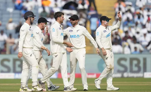 New Zealand's Mitchell Santner, third from left, celebrates the dismissal of India's Ravichandran Ashwin with his team mates during the day three of the second cricket test match between India and New Zealand at the Maharashtra Cricket Association Stadium , in Pune, India, Saturday, Oct. 26, 2024. (AP Photo/Rafiq Maqbool)