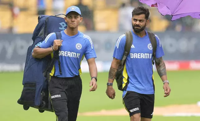 India's Virat Kohli, right, and Yashasvi Jaiswal walk across the field after rains delayed the start of the day one of the first cricket test match between India and New Zealand at the M.Chinnaswamy Stadium, in Bengaluru, India, Wednesday, Oct. 16, 2024. (AP Photo/Aijaz Rahi)