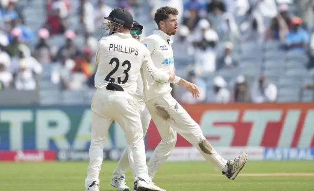 New Zealand's Mitchell Santner, right, celebrates the dismissal of India's Ravichandran Ashwin with his team mates during the day two of the second cricket test match between India and New Zealand at the Maharashtra Cricket Association Stadium , in Pune, India, Friday, Oct. 25, 2024. (AP Photo/Rafiq Maqbool)