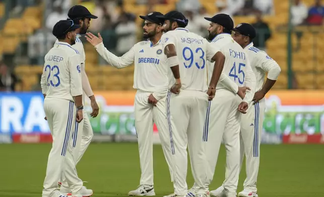 India's Virat Kohli, third left, talks to his teammates after bad light stopped play on the day four of the first cricket test match between India and New Zealand at the M.Chinnaswamy Stadium, in Bengaluru, India, Saturday, Oct. 19, 2024. (AP Photo/Aijaz Rahi)