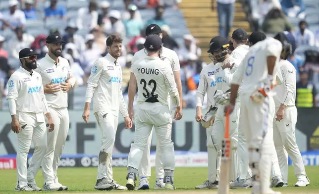 New Zealand's Mitchell Santner, third from left, celebrates the dismissal of India's Sarfaraz Khan with his team mates during the day two of the second cricket test match between India and New Zealand at the Maharashtra Cricket Association Stadium , in Pune, India, Friday, Oct. 25, 2024. (AP Photo/Rafiq Maqbool)