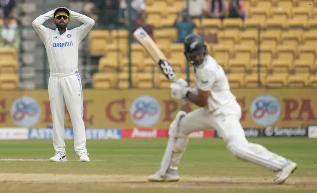 India's Virat Kohli, left, reacts as New Zealand's Rachin Ravindra, right, bats during the day five of the first cricket test match between India and New Zealand at the M.Chinnaswamy Stadium, in Bengaluru, India, Sunday, Oct. 20, 2024. (AP Photo/Aijaz Rahi)