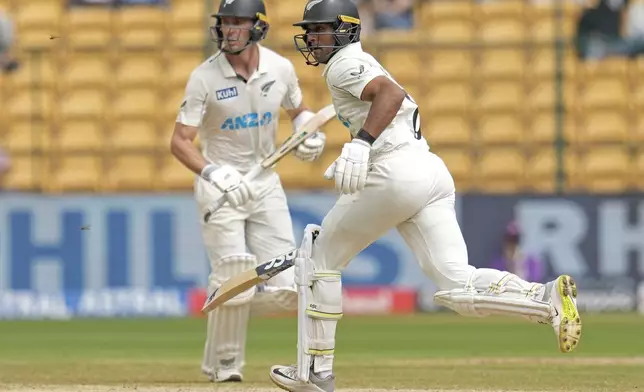 New Zealand's Rachin Ravindra, right, and Will Young run between the wickets to score during the day five of the first cricket test match between India and New Zealand at the M.Chinnaswamy Stadium, in Bengaluru, India, Sunday, Oct. 20, 2024. (AP Photo/Aijaz Rahi)