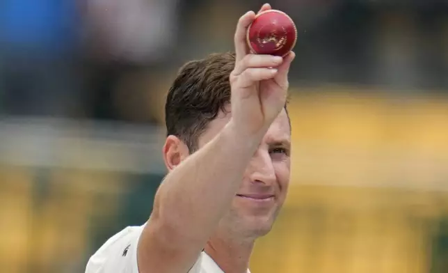 New Zealand's Matt Henry holds up the ball as he leaves the field after taking the five wickets during the day two of the first cricket test match between India and New Zealand at the M.Chinnaswamy Stadium, in Bengaluru, India, Thursday, Oct. 17, 2024. (AP Photo/Aijaz Rahi)