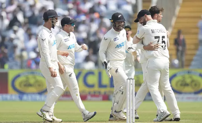 New Zealand's Mitchell Santner ,second from right, celebrates the dismissal of India's captain Rohit Sharma with his team mates during the day three of the second cricket test match between India and New Zealand at the Maharashtra Cricket Association Stadium , in Pune, India, Saturday, Oct. 26, 2024. (AP Photo/Rafiq Maqbool)