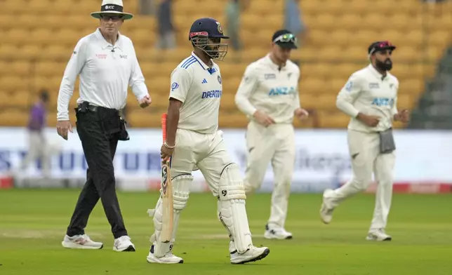 India's Rishabh Pant, second left, leaves the field after rain stopped play on the day two of the first cricket test match between India and New Zealand at the M.Chinnaswamy Stadium, in Bengaluru, India, Thursday, Oct. 17, 2024. (AP Photo/Aijaz Rahi)