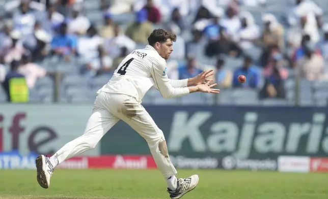 New Zealand's Mitchell Santner fields the ball during the day two of the second cricket test match between India and New Zealand at the Maharashtra Cricket Association Stadium , in Pune, India, Friday, Oct. 25, 2024. (AP Photo/Rafiq Maqbool)