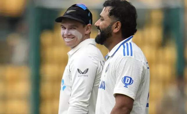 India's captain Rohit Sharma, right, and New Zealand's captain Tom Latham walk into the field on the day two of the first cricket test match between India and New Zealand at the M.Chinnaswamy Stadium, in Bengaluru, India, Thursday, Oct. 17, 2024. (AP Photo/Aijaz Rahi)