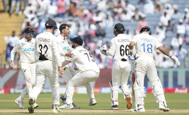 New Zealand's Mitchell Santner, third from left, celebrates the dismissal of India's Virat Kohli with his team mates during the day three of the second cricket test match between India and New Zealand at the Maharashtra Cricket Association Stadium , in Pune, India, Saturday, Oct. 26, 2024. (AP Photo/Rafiq Maqbool)