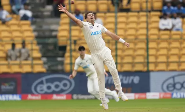 New Zealand's Tim Southee jumps to field the ball on his own bowling after a shot played by India's Yashasvi Jaiswal during the day two of the first cricket test match between India and New Zealand at the M.Chinnaswamy Stadium, in Bengaluru, India, Thursday, Oct. 17, 2024. (AP Photo/Aijaz Rahi)