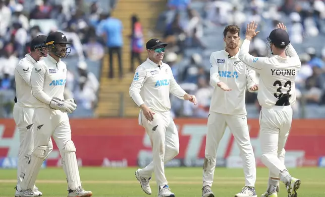 New Zealand's Mitchell Santner, second from right, celebrates the dismissal of India's Ravichandran Ashwin with his team mates during the day two of the second cricket test match between India and New Zealand at the Maharashtra Cricket Association Stadium , in Pune, India, Friday, Oct. 25, 2024. (AP Photo/Rafiq Maqbool)