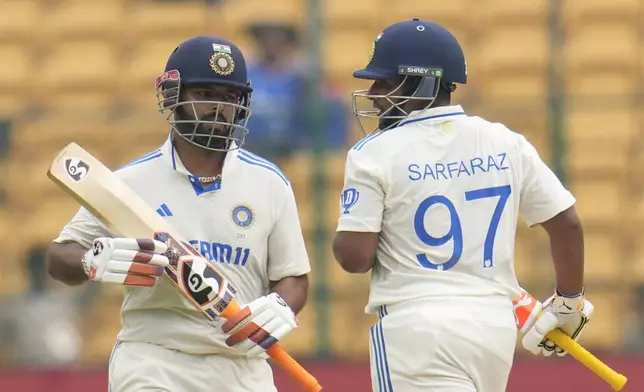 India's Sarfaraz Khan, right, and Rishabh Pant run between the wickets to score during the day four of the first cricket test match between India and New Zealand at the M.Chinnaswamy Stadium, in Bengaluru, India, Saturday, Oct. 19, 2024. (AP Photo/Aijaz Rahi)