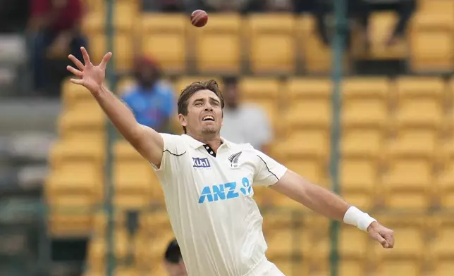 New Zealand's Tim Southee jumps to field the ball on his own bowling after a shot played by India's Yashasvi Jaiswal during the day two of the first cricket test match between India and New Zealand at the M.Chinnaswamy Stadium, in Bengaluru, India, Thursday, Oct. 17, 2024. (AP Photo/Aijaz Rahi)