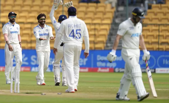 India's Ravindra Jadeja, second left, celebrates with teammates after the dismissal of New Zealand's Glenn Philips, right, during the day three of the first cricket test match between India and New Zealand at the M.Chinnaswamy Stadium, in Bengaluru, India, Friday, Oct. 18, 2024. (AP Photo/Aijaz Rahi)