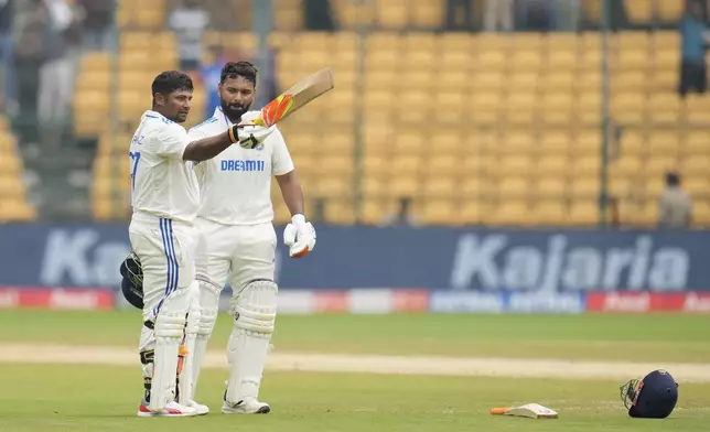 India's Sarfaraz Khan, left, celebrates after scoring a century during the day four of the first cricket test match between India and New Zealand at the M.Chinnaswamy Stadium, in Bengaluru, India, Saturday, Oct. 19, 2024. (AP Photo/Aijaz Rahi)