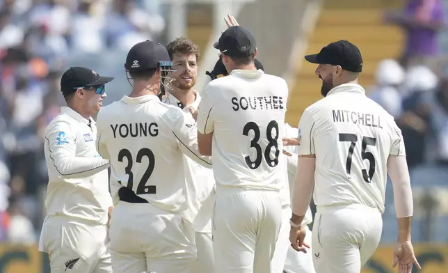 New Zealand's Mitchell Santner , centre, celebrates the dismissal of India's captain Rohit Sharma with his team mates during the day three of the second cricket test match between India and New Zealand at the Maharashtra Cricket Association Stadium , in Pune, India, Saturday, Oct. 26, 2024. (AP Photo/Rafiq Maqbool)