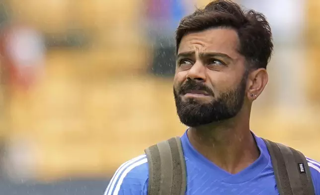 India's Virat Kohli looks skywards as he walks across the field after rains delayed the start of the day one of the first cricket test match between India and New Zealand at the M.Chinnaswamy Stadium, in Bengaluru, India, Wednesday, Oct. 16, 2024. (AP Photo/Aijaz Rahi)