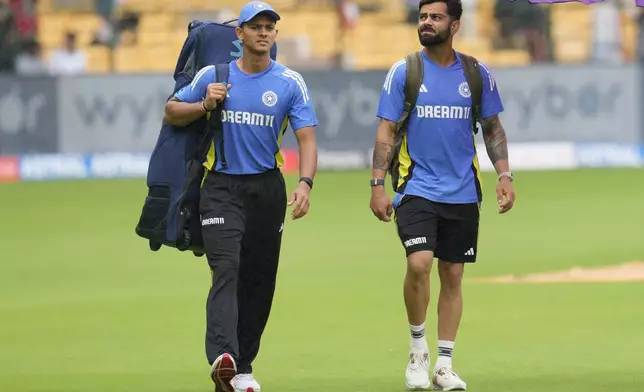 India's Virat Kohli, right, and Yashasvi Jaiswal walk across the field after rains delayed the start of the day one of the first cricket test match between India and New Zealand at the M.Chinnaswamy Stadium, in Bengaluru, India, Wednesday, Oct. 16, 2024. (AP Photo/Aijaz Rahi)