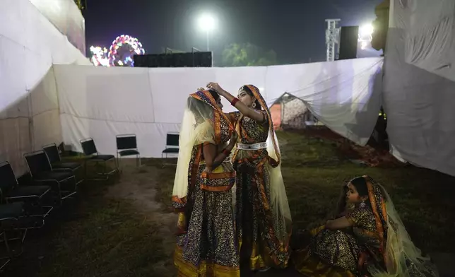 Actors get ready backstage before the start of Ramleela, a dramatic folk re-enactment of the life of Hindu god Rama according to the ancient Hindu epic Ramayana, in New Delhi, India, Saturday, Oct. 5, 2024. (AP Photo/Manish Swarup)