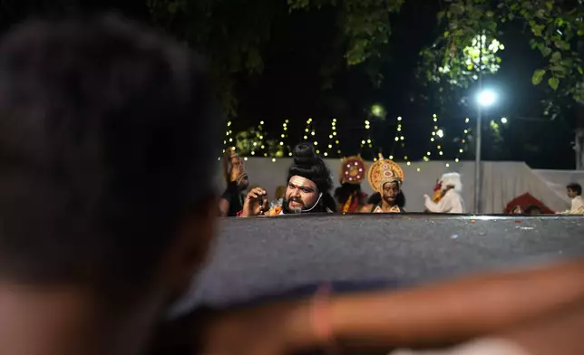 An actor takes directions backstage before the start of Ramleela, a dramatic folk re-enactment of the life of Hindu god Rama according to the ancient Hindu epic Ramayana, in New Delhi, India, Wednesday, Oct. 9, 2024. (AP Photo/Manish Swarup)