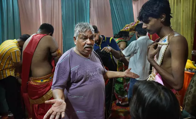 Theatre director Rakesh Ratnakar, 65, gives instructions to the actors backstage before the start of Ramleela, a dramatic folk re-enactment of the life of Hindu god Rama according to the ancient Hindu epic Ramayana, in New Delhi, India, Saturday, Oct. 5, 2024. (AP Photo/Manish Swarup)