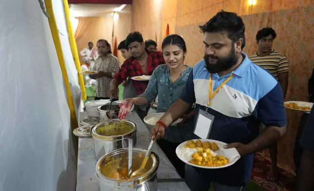 Hitanshi Jha, 21, an actor playing the character of Sita, second right, takes dinner with other actors after performing in Ramleela, a dramatic folk re-enactment of the life of Hindu god Rama according to the ancient Hindu epic Ramayana, in New Delhi, India, Wednesday, Oct. 9, 2024. (AP Photo/Manish Swarup)