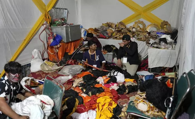 Production assistants sort costumes backstage during Ramleela, a dramatic folk re-enactment of the life of Hindu god Rama according to the ancient Hindu epic Ramayana, in New Delhi, India, Wednesday, Oct. 9, 2024. (AP Photo/Manish Swarup)