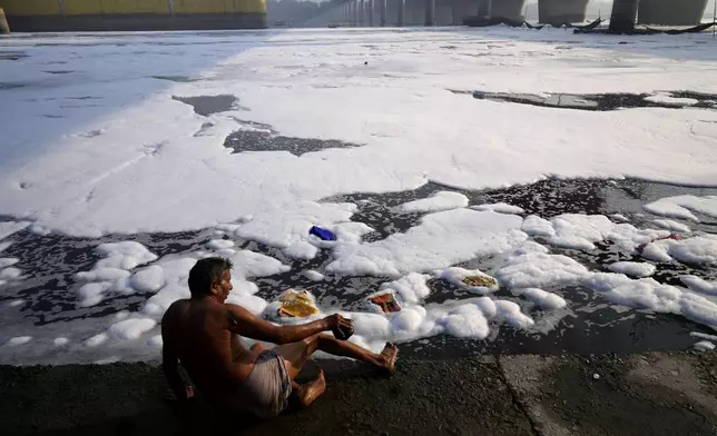 Jasraj, 70, takes bath on the banks of the the river Yamuna filled with toxic foams in New Delhi, India, Tuesday, Oct. 29, 2024. (AP Photo/Manish Swarup)