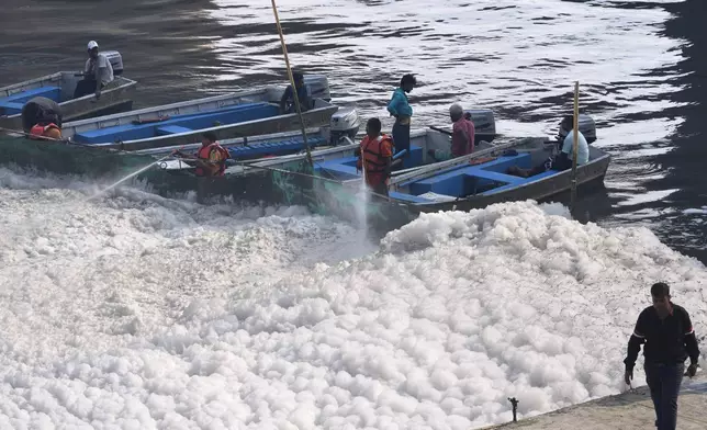 Workers for the Delhi Jal or water board spray chemical to clean the toxic foams in the river Yamuna in New Delhi, India, Tuesday, Oct. 29, 2024. (AP Photo/Manish Swarup)