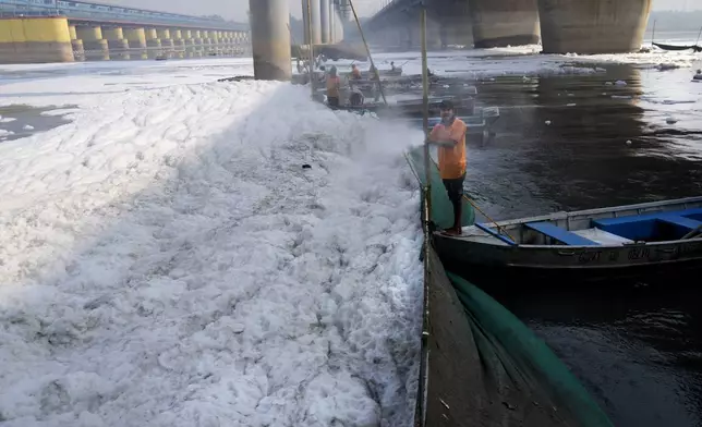 A worker for the Delhi Jal or water board sprays chemical to clean the toxic foams in the river Yamuna in New Delhi, India, Tuesday, Oct. 29, 2024. (AP Photo/Manish Swarup)